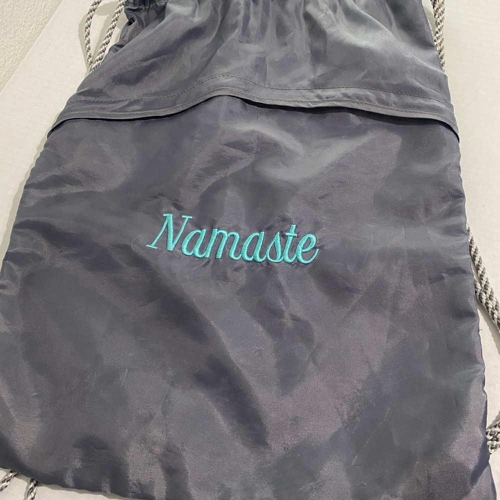 Drawstring unstructured backpack. “Namaste”embroidered in turquoise.